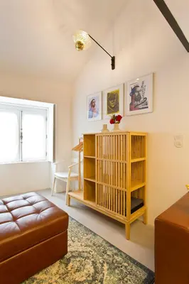 a living room with a couch and a book shelf at Luiz I Optimum Lofts 01 in Porto