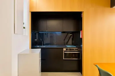 a kitchen with black cabinets and a microwave at Luiz I Optimum Lofts 01 in Porto