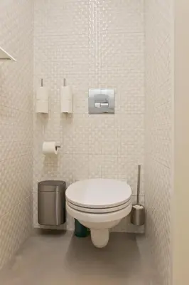 a white bathroom with a toilet and a trash can at Luiz I Optimum Lofts 01 in Porto