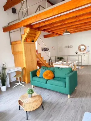 a living room with a green couch with pillows at Mezzanine encantador no Porto in Porto