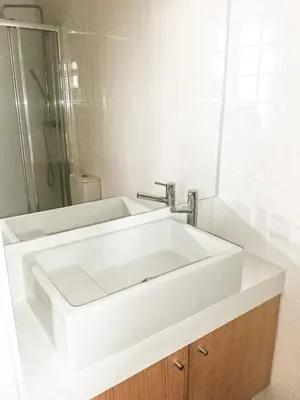 a bathroom with a white sink and a shower at Mezzanine encantador no Porto in Porto