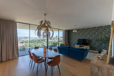 a living room with a table and a blue couch at GuestReady - Urban luxury with Douro view in Vila Nova de Gaia