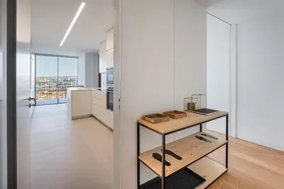 a kitchen with white walls and a wooden table at GuestReady - Urban luxury with Douro view in Vila Nova de Gaia