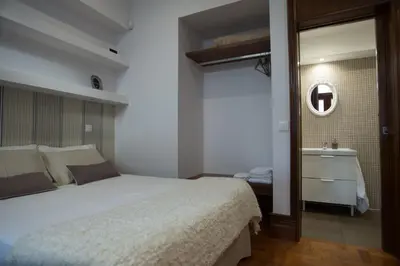 a bedroom with a bed and a sink and a mirror at Nidos Accommodation Gaia in Vila Nova de Gaia
