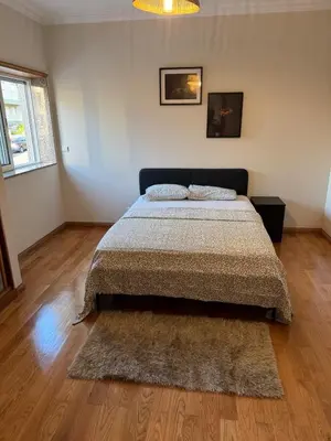a bedroom with a bed and a wooden floor at Hostel Antas Porto in Porto