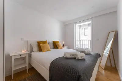 a white bedroom with a large bed and a window at GuestReady - Relaxing Getaway Near Porto in Vila Nova de Gaia