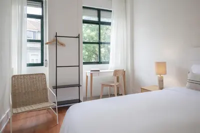 a white bedroom with a bed and a chair and a desk at Casa Verde by Olala Homes in Porto