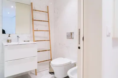 a white bathroom with a toilet and a sink at Studio w/ Balcony, Pool & Gym | Antas by Host Wise in Porto