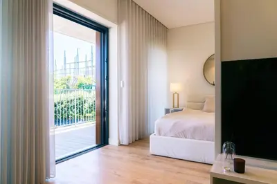a bedroom with a bed and a sliding glass door at Studio w/ Balcony, Pool & Gym | Antas by Host Wise in Porto