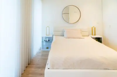 a bedroom with a large bed with a mirror on the wall at Studio w/ Balcony, Pool & Gym | Antas by Host Wise in Porto
