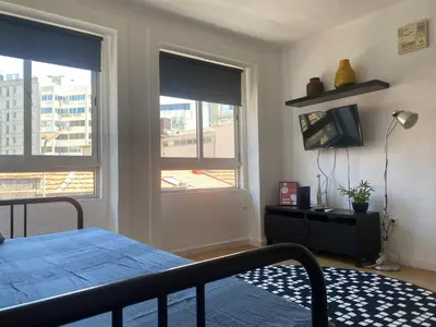a bedroom with a bed and a tv and two windows at Oporto Perfect Days - Downtown in Porto