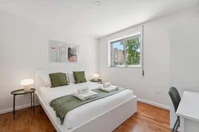 a white bedroom with a bed and a window at GuestReady - Fantastic family home in Salgueiros in Porto