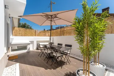 a patio with a table and chairs and an umbrella at GuestReady - Fantastic family home in Salgueiros in Porto