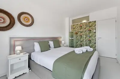 a bedroom with a large white bed and a window at GuestReady - Lovely home with river view in Vila Nova de Gaia