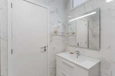 a white bathroom with a sink and a mirror at GuestReady - Lovely home with river view in Vila Nova de Gaia