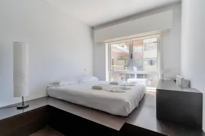 a white bedroom with a bed and a window at Spacious 2BR en suite, downtown Porto in Porto