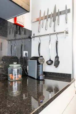 a kitchen with knives and utensils hanging on the wall at Spacious 2BR en suite, downtown Porto in Porto