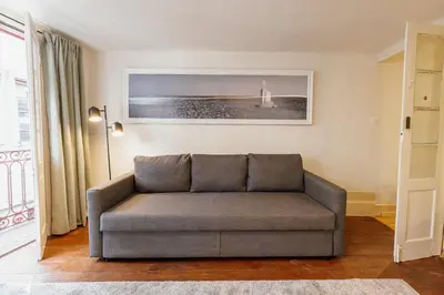 a living room with a bed and chairs and a tv at Charming Apartment by Hosty in Porto