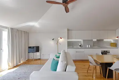 a white couch with blue pillows in a living room at Casas do Rivoli in Porto