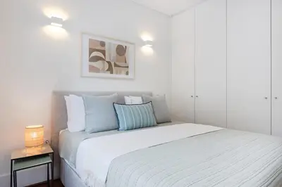 a living room with a couch and a table with a laptop at Patio Retreat | Porto Urban Flats in Porto