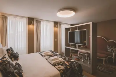 a hotel room with a bed and a television at Viterbo'8 - Bonjardim Apartments in Porto