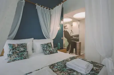a bedroom with a bed with a picture of a man playing the piano at Viterbo'8 - Bonjardim Apartments in Porto