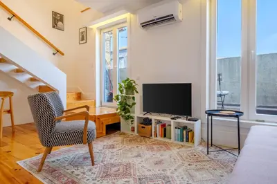 a living room with a chair and a television at Porto Santo Ildefonso Central Loft in Porto