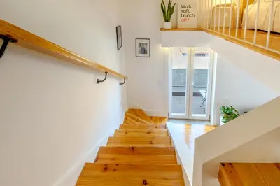 a staircase in a home with white walls and wood floors at Porto Santo Ildefonso Central Loft in Porto