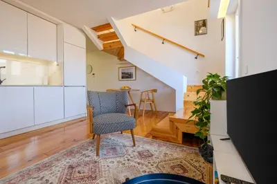 a living room with a chair and a staircase at Porto Santo Ildefonso Central Loft in Porto