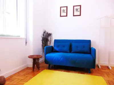 a blue couch in a living room with a table at Aida's Haven - Bolhão in Porto