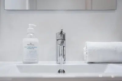 a bathroom sink with a bottle of soap and a towel at Trindade Duo Apartments in Porto