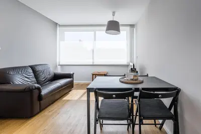 a living room with a table and a couch at Trindade Duo Apartments in Porto