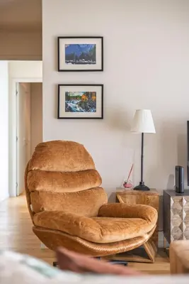 a living room with a brown chair and a lamp at Gaia Land Sea View Apartment in Vila Nova de Gaia