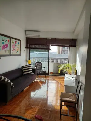 a living room with a couch and a large window at Trindade Apartment in Porto