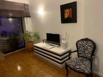 a desk with a computer and a chair in a room at Trindade Apartment in Porto