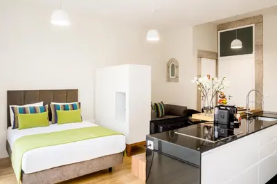 a hotel room with a bed and a kitchen at Oportolazaro Premium Downtown Porto in Porto