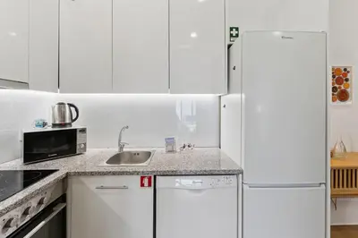 a white kitchen with white cabinets and a refrigerator at GuestReady - Relaxing Porto stay in Porto