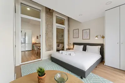 a bedroom with a large white bed and a table at GuestReady - Relaxing Porto stay in Porto