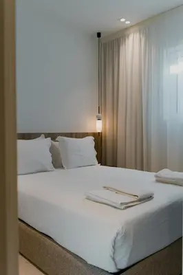 a large white bed with two books on it at ORM - Santa Teresa Apartments in Porto