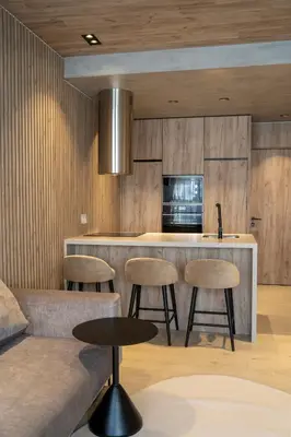 a kitchen with a bar with stools and a couch at ORM - Santa Teresa Apartments in Porto