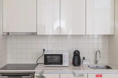 a kitchen counter with a microwave and a sink at Liiiving in Porto - Urban Retreat Apartment in Porto