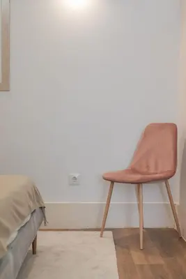 a chair sitting in a room next to a bed at Liiiving in Porto - Urban Retreat Apartment in Porto