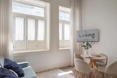 a living room with a table and two windows at Liiiving in Porto - Urban Retreat Apartment in Porto