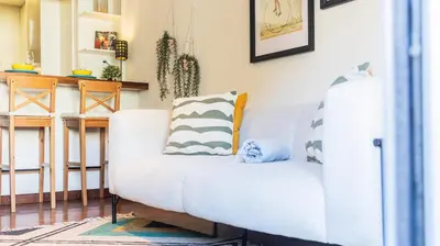 a living room with a white couch with pillows on it at Adorable apartment center Nao in Porto