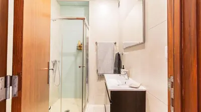 a white bathroom with a sink and a shower at Adorable apartment center Nao in Porto
