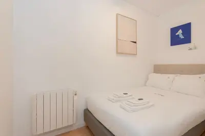 a small bedroom with a white bed and a mirror at Liiiving in Porto - Invictus Bolhao Market in Porto