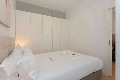 a white bed with white sheets and pillows at Liiiving in Porto - Invictus Bolhao Market in Porto