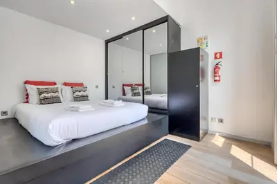 a bedroom with a large white bed and a mirror at Ribeira Dreams in Porto
