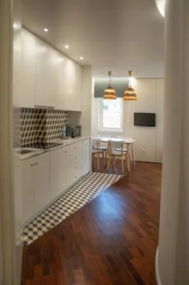 a kitchen with white cabinets and a table with chairs at Oporto Riverside Rooftop in Porto