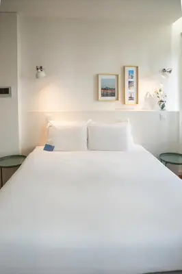 a bedroom with a large white bed with two tables at Oporto Riverside Rooftop in Porto